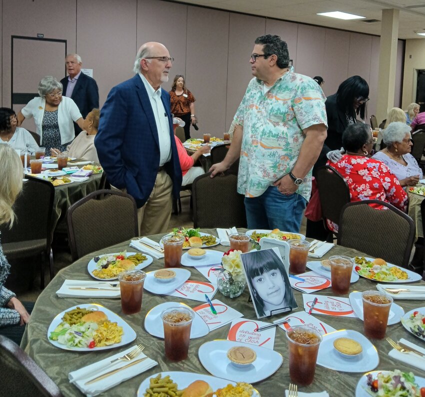 Commissioner Greg Vick, left, talks with Chris White, County planning director, during Tuesday's CASA luncheon. State Rep. Pat Marsh, background, has been supportive of CASA for many years, as well as other legislators and state representatives.