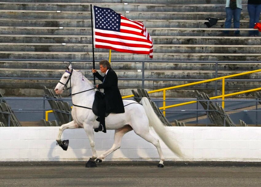 Vicki Self brings in the American Flag Wednesday night at the opening ceremonies of the 87th Annual Celebration.