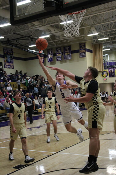Charlie Haskins (3) attacks the basket and lays in two of his team-high 22 points in Friday's OT loss to Clay County.