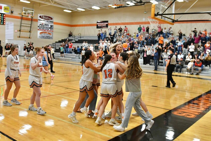 Cascade celebrates by mobbing Kaegan Young (22) after her game-winning half-court buzzer-beater against Moore County on Saturday.