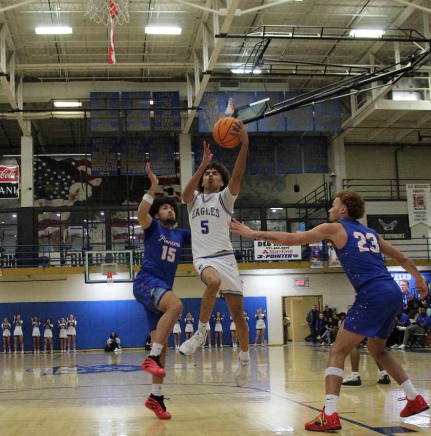 Malek Johnson (5) soars between Warren County's Deashawn Adams (15) and Keyton Reno (23) for two of his 11 points in Shelbyville's District 6-AAAA blowout win over the Pioneers on Friday night.