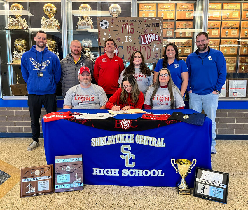 MG Marshall (center) signs with Bryan College on Jan. 20 with Shelbyville's Casey Curry (middle, right) and Bryan College's Jake Warren (middle, left) behind her.