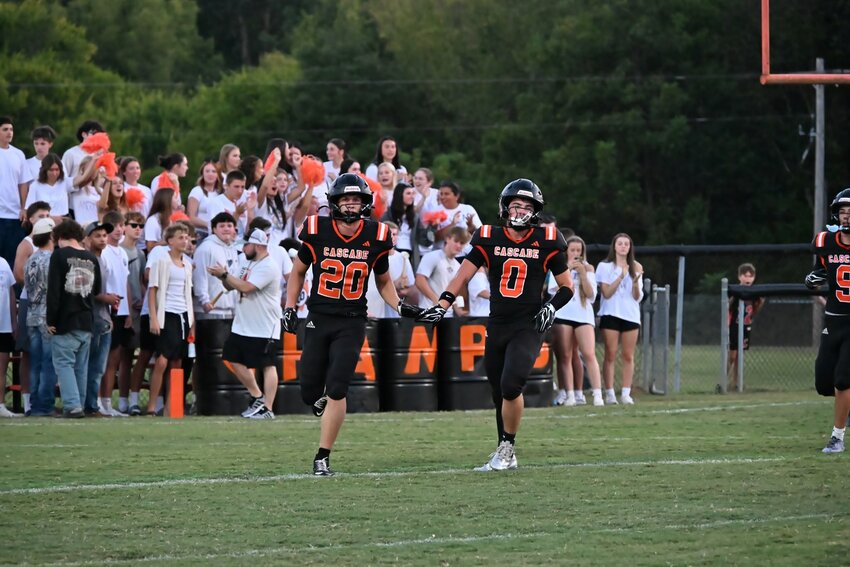 Cascade's Nate Zimmerman (20) and Braxtyn Burris (0) trot to the sideline after Zimmerman's 14-yard touchdown run in the first quarter. Zimmerman finished with 87 yards rushing and one touchdown on 15  attempts.