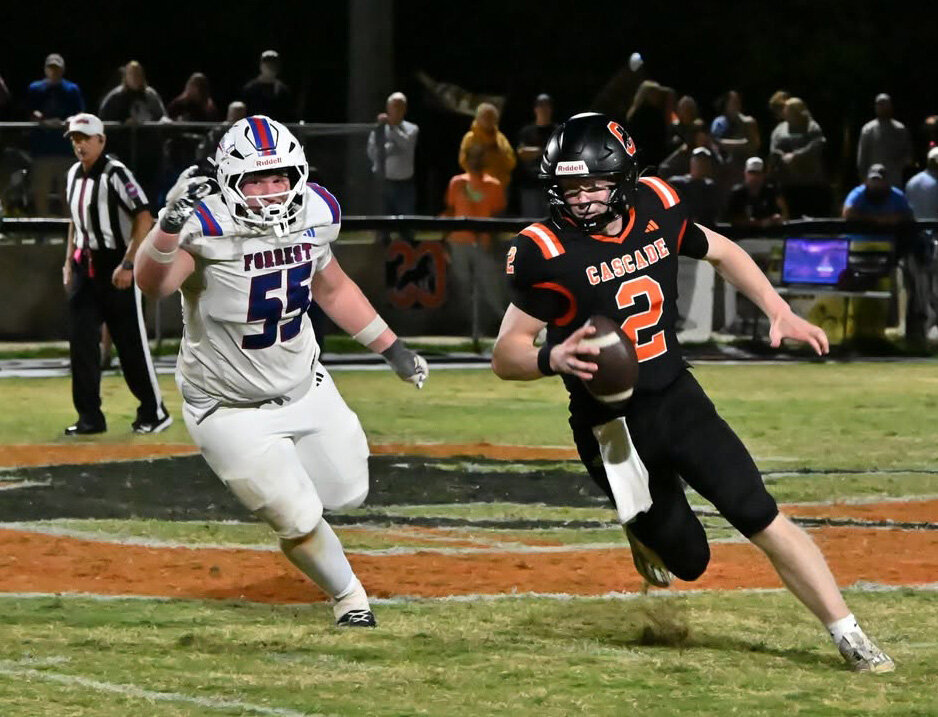 Cascade's Sam Bradley (2) escapes Chapel Hill's Lochlin Morris (55) on Friday night. Bradley finished 20-of-34 for 277 yards and two touchdowns with one interception through the air while running for 158 yards and two touchdowns on the ground in the loss.