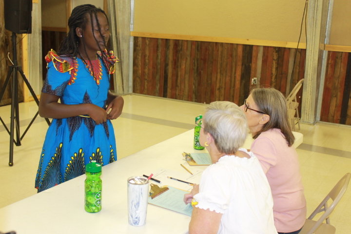 Rebecca “Angel” Mukisa of the Royal Clovers 4-H Club explains to judges Anne Patrick and Diana Holland how she made her dress for the Fashion Revue.