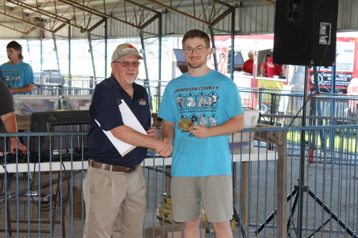 Larry Smith of KMMO presents August Hoeper of the Mt. Moriah Hustlers 4-H Club with the Youth In Agriculture Award.