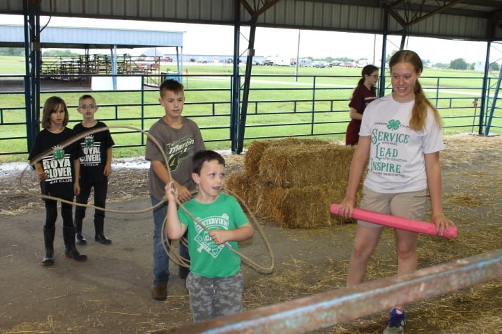 Members of the Royal Clovers 4-H Club (Keira Myers, Owen Myers and Lane Throckmorton) support their teammate Max Krewson as he attempts to lasso a target.