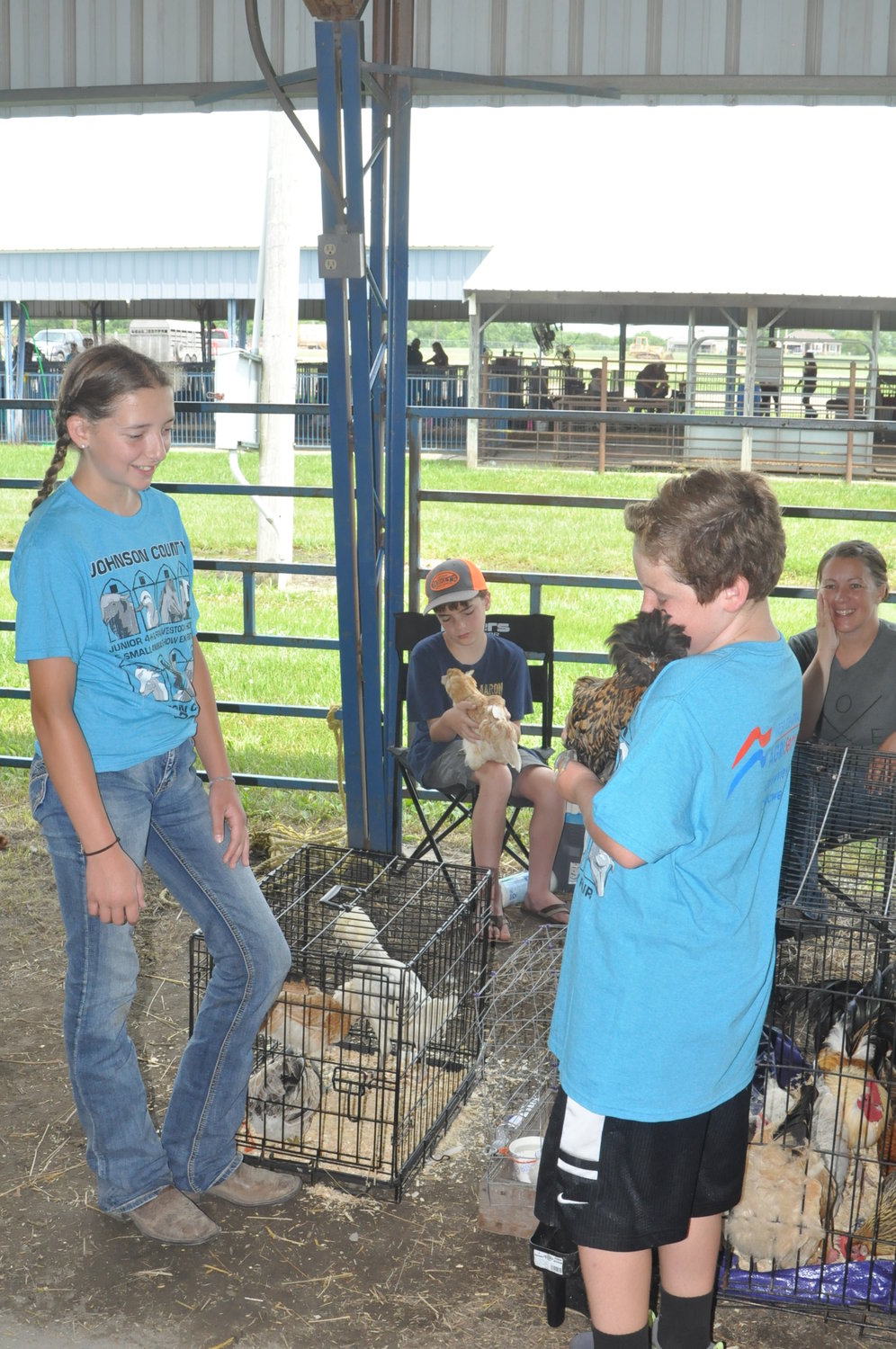 Grayci Holcomb of the Blackwater Bobcats 4-H Club lets Gaige Zwally of the Mt. Moriah Hustlers 4-H Club hold one of her chickens prior to the Poultry Show.