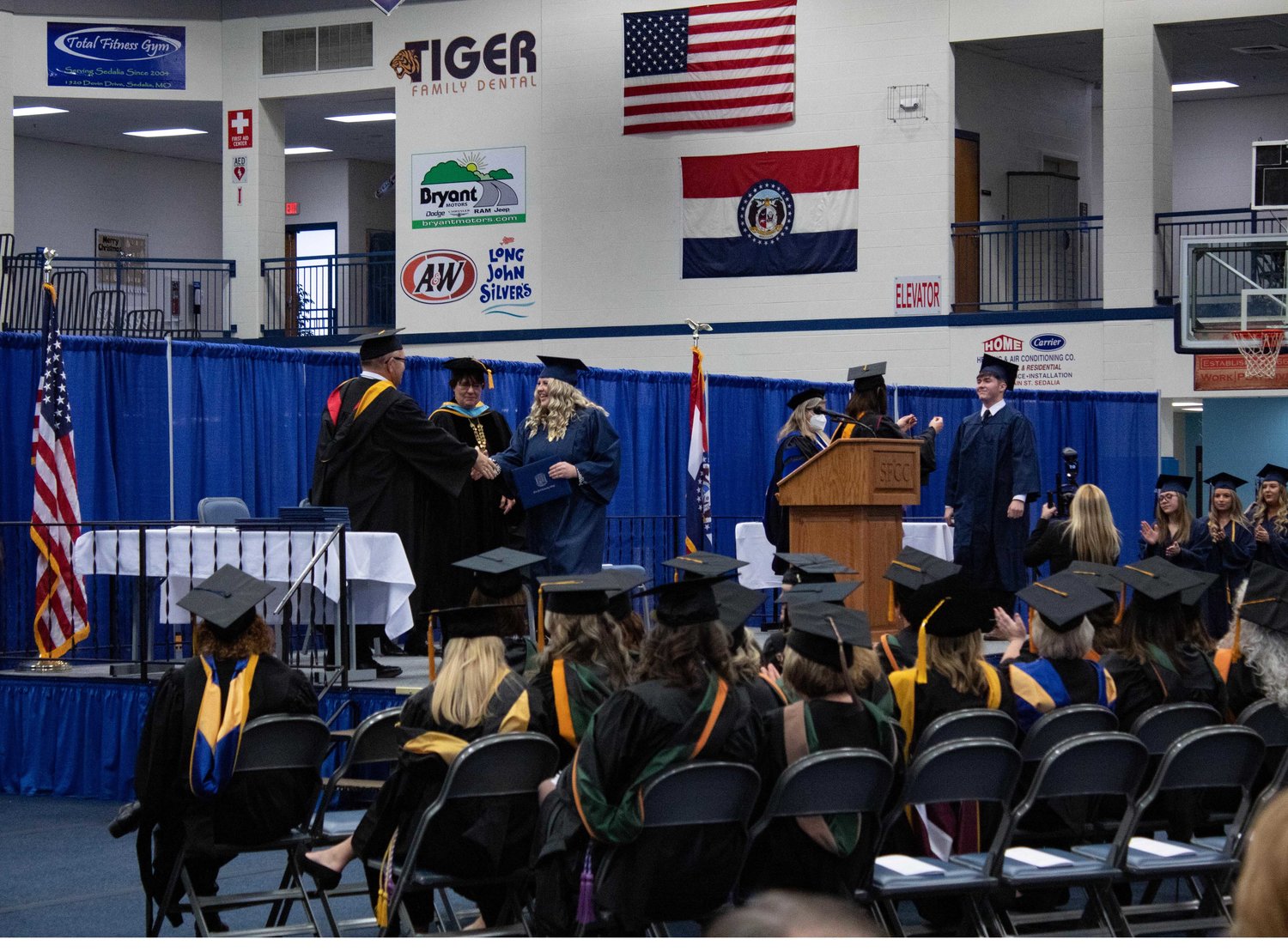 From left, Board of Trustee member Tim Carr and SFCC President Dr. Joanna Anderson congratulate and present diplomas to students while Dean Dr. Rhonda Hutton Gann and nursing faculty perform the pinning ceremony on the right.