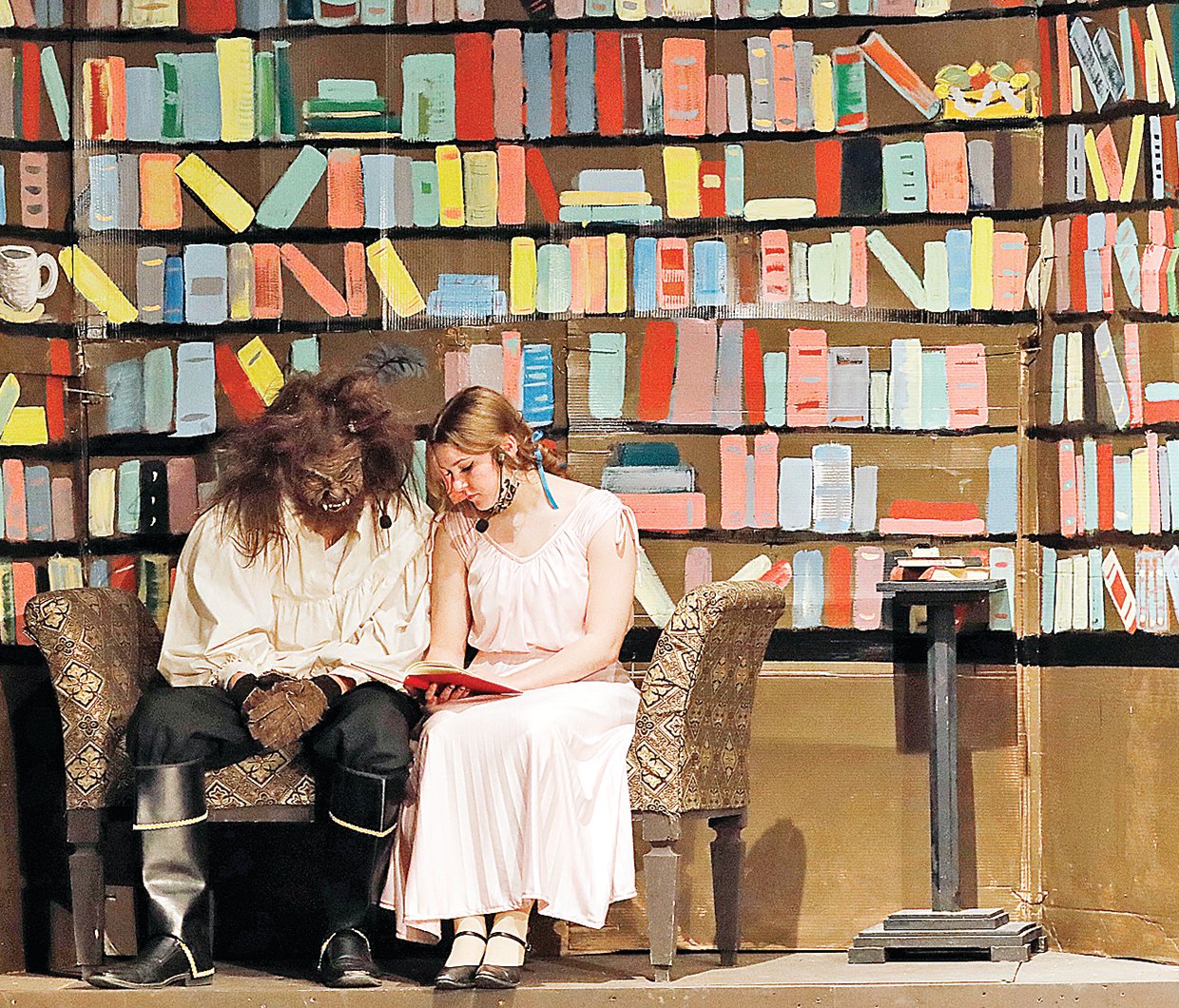 Belle, played by Sidney Marshall, reads to the Beast, Bryce Fairchild.
