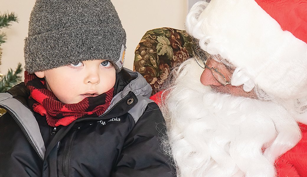 Four-year-old Maverick Wright pondered what else he would like for Christmas while sitting on Santa’s lap during Orr’s Snow City Christmas 
festival on Saturday.