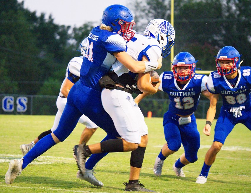 Carson Johnson wraps up the Hawks ball-carrier as Wyatt Hightower (12) and Thomas Sabedra (88) prepare to assist with the tackle.