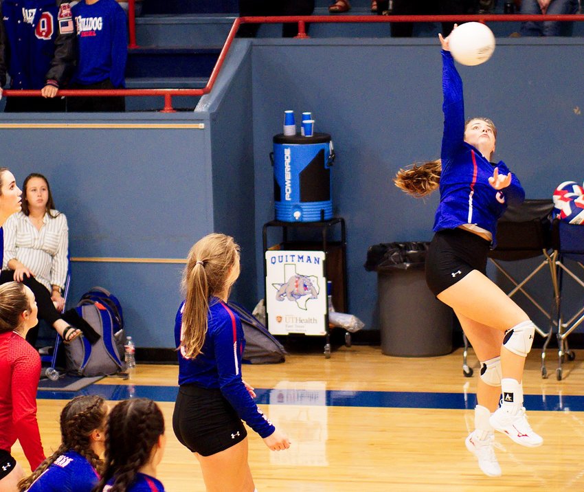 Kaysi Parker spikes the ball for Quitman as her teammates watch.